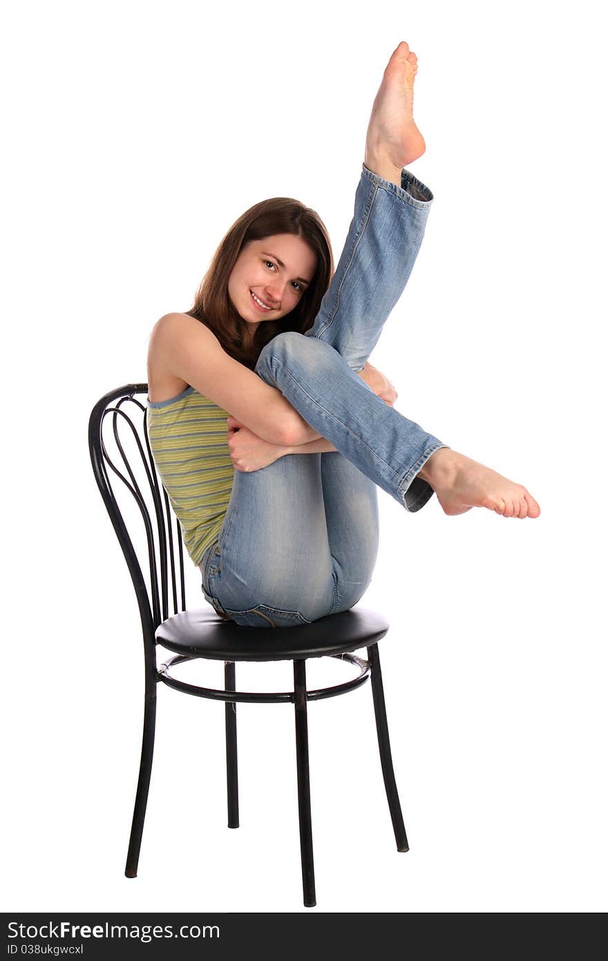 Girl in green stripy top sit on stool tuck up legs. Isolated on white. Girl in green stripy top sit on stool tuck up legs. Isolated on white.