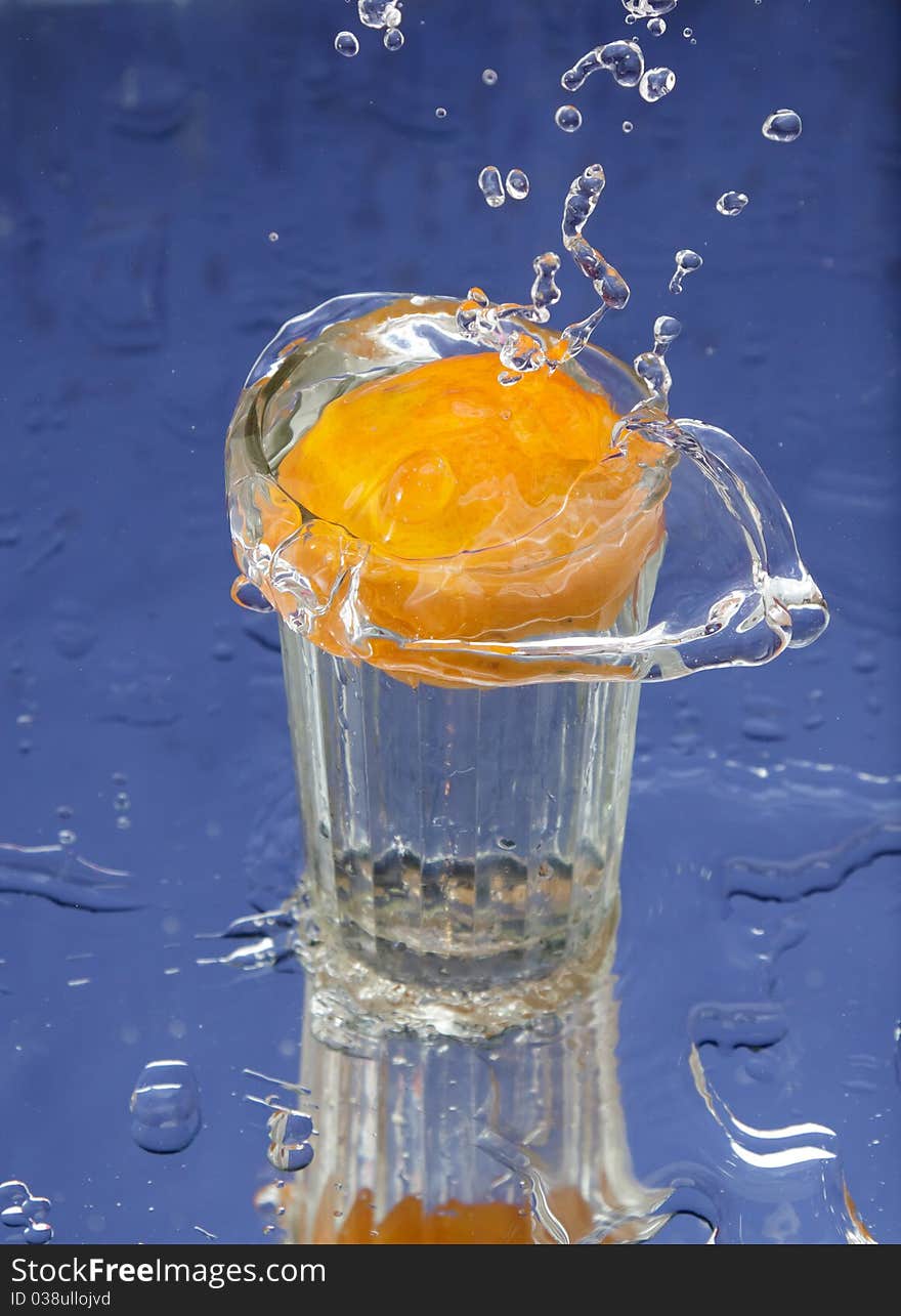 Orange and splash water over blue background