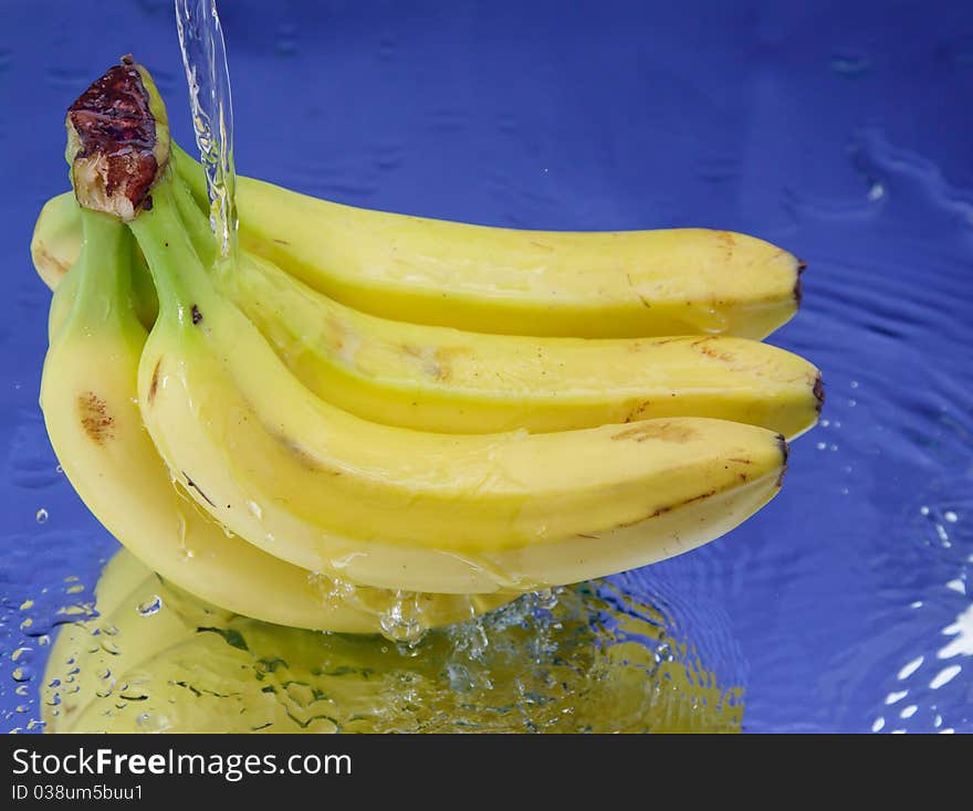 Banana and splash water over blue background