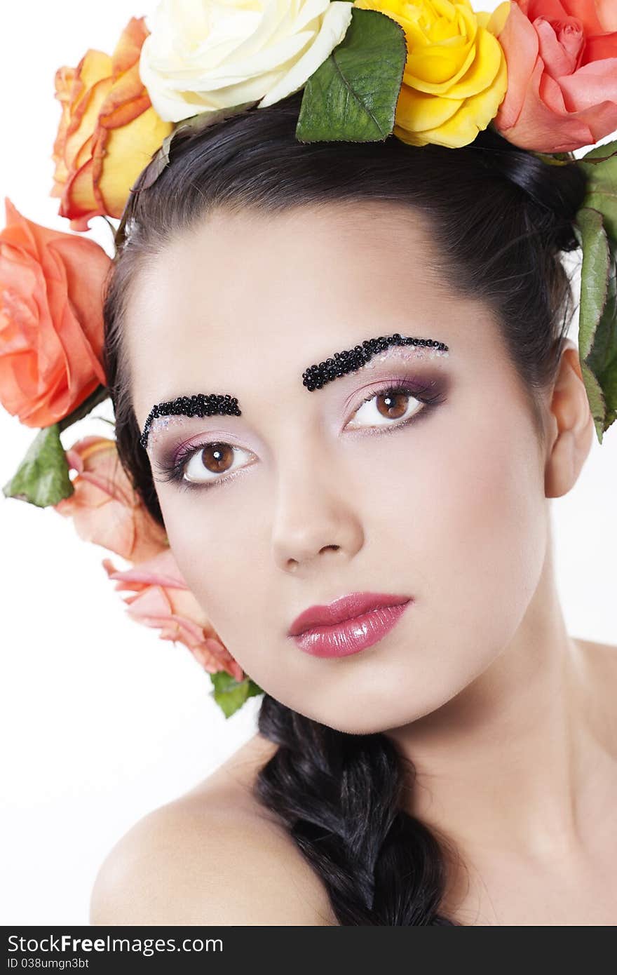 Portrait of young beautiful woman with roses in hair, on white background