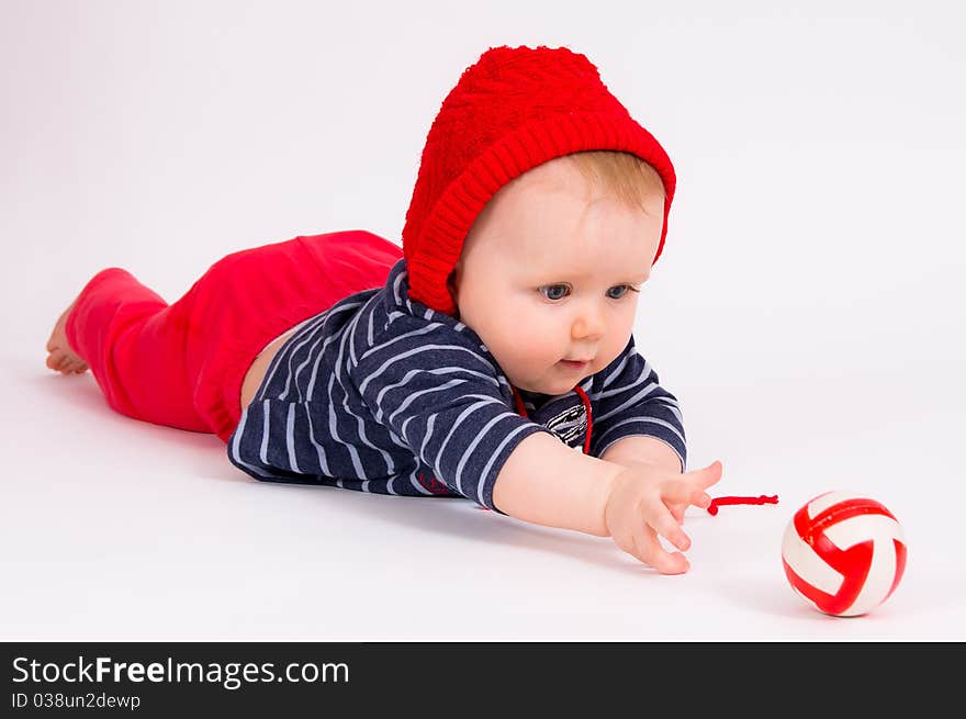 Little child baby crawling for the red ball