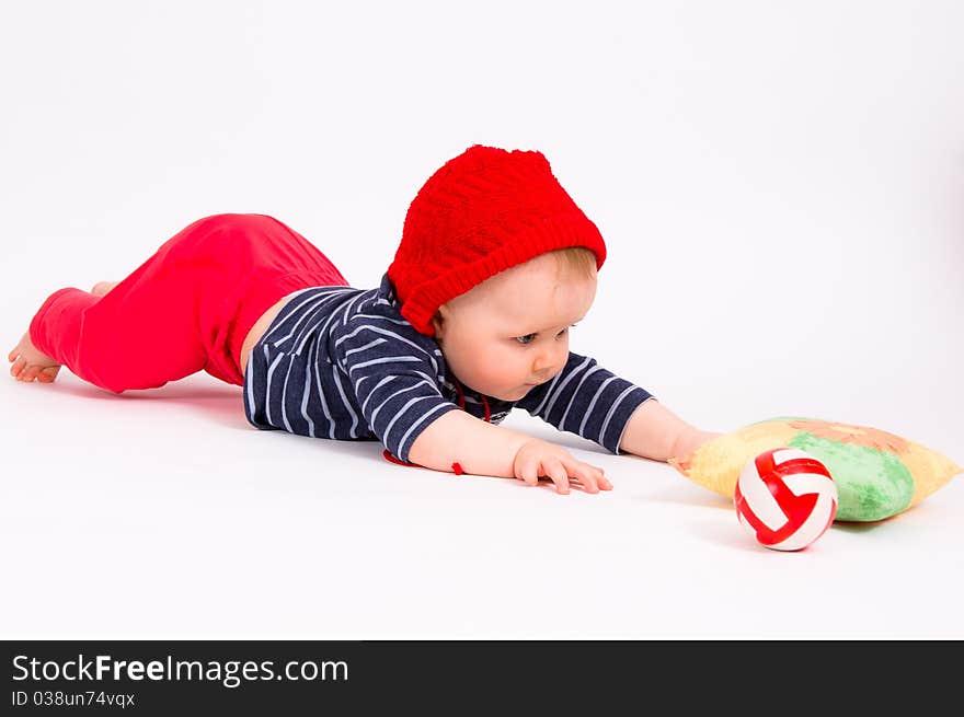 Little child baby crawling for the red ball