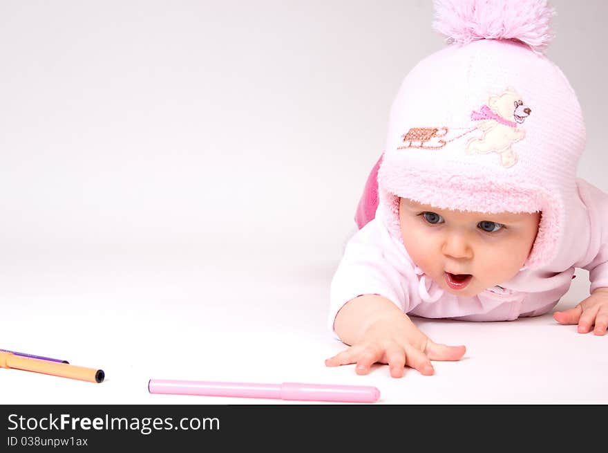 Little child baby crawling for the colored markers. Little child baby crawling for the colored markers