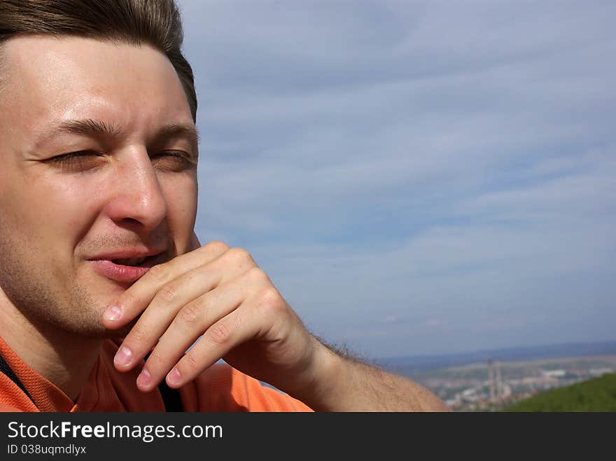 Portrait of a handsome young man with nice scenery of town as a background. Close-up. Portrait of a handsome young man with nice scenery of town as a background. Close-up.