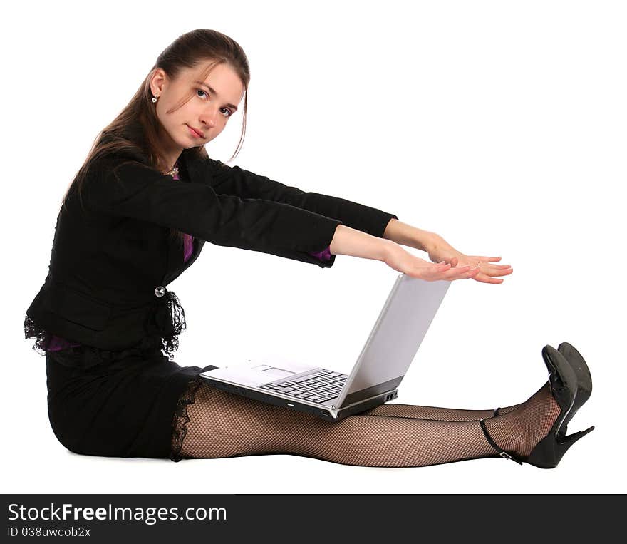 Girl in black suit sits on floor with laptop. Isolated on white.