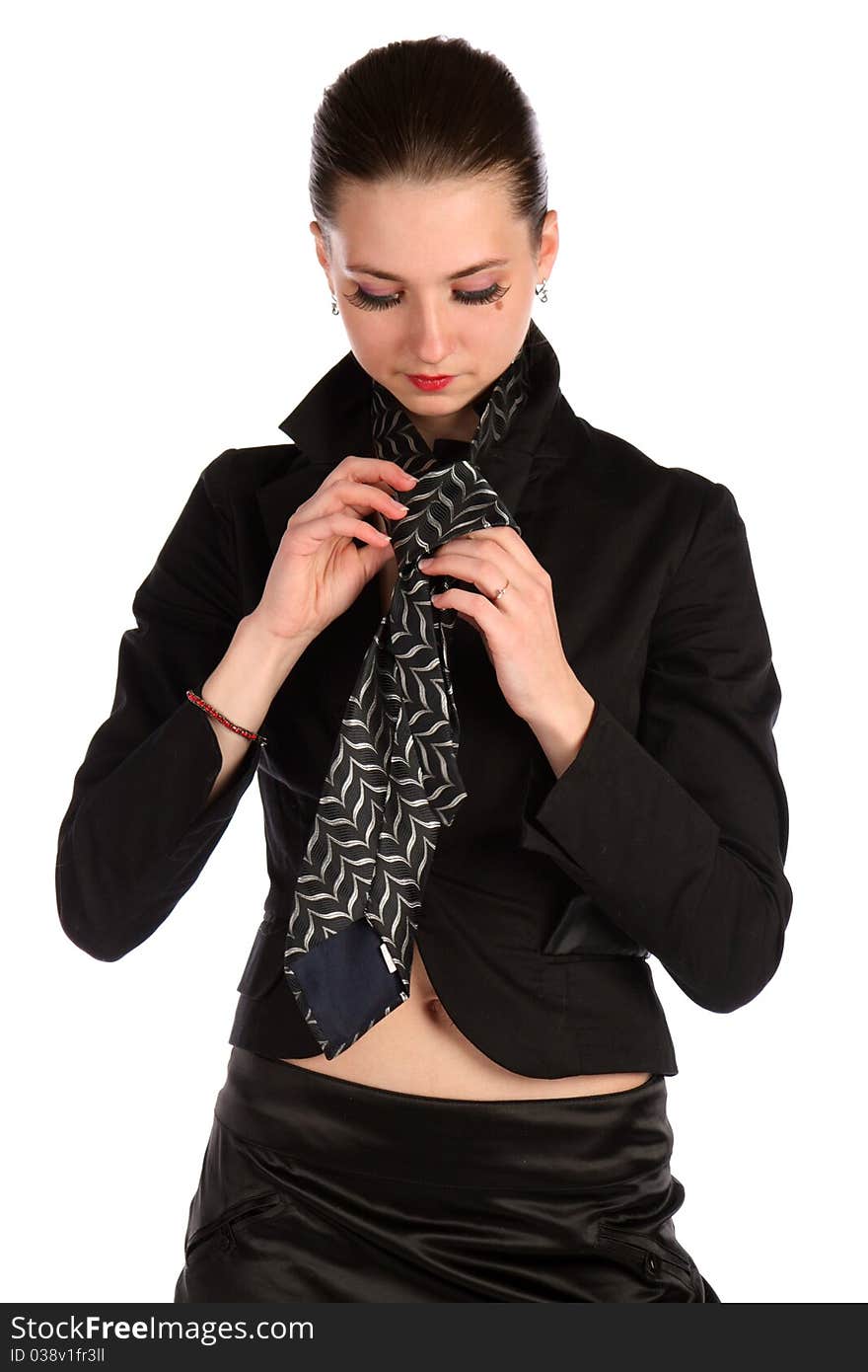 Girl in black suit makes necktie.