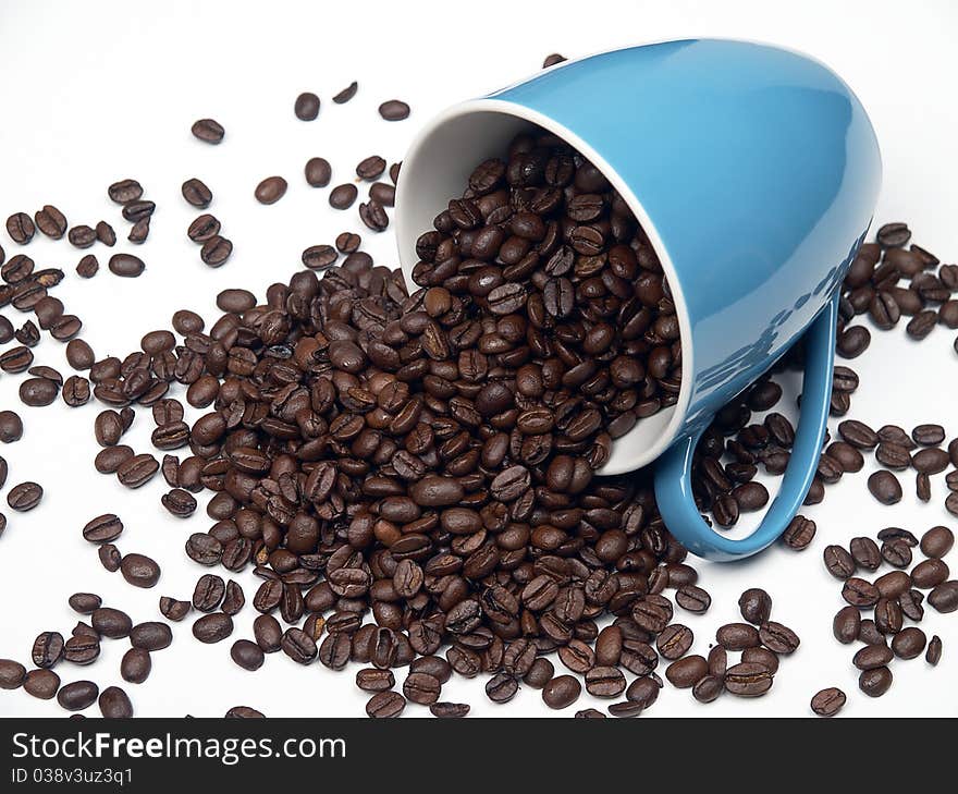 The image shows a part of a coffee cup filled with coffee beans