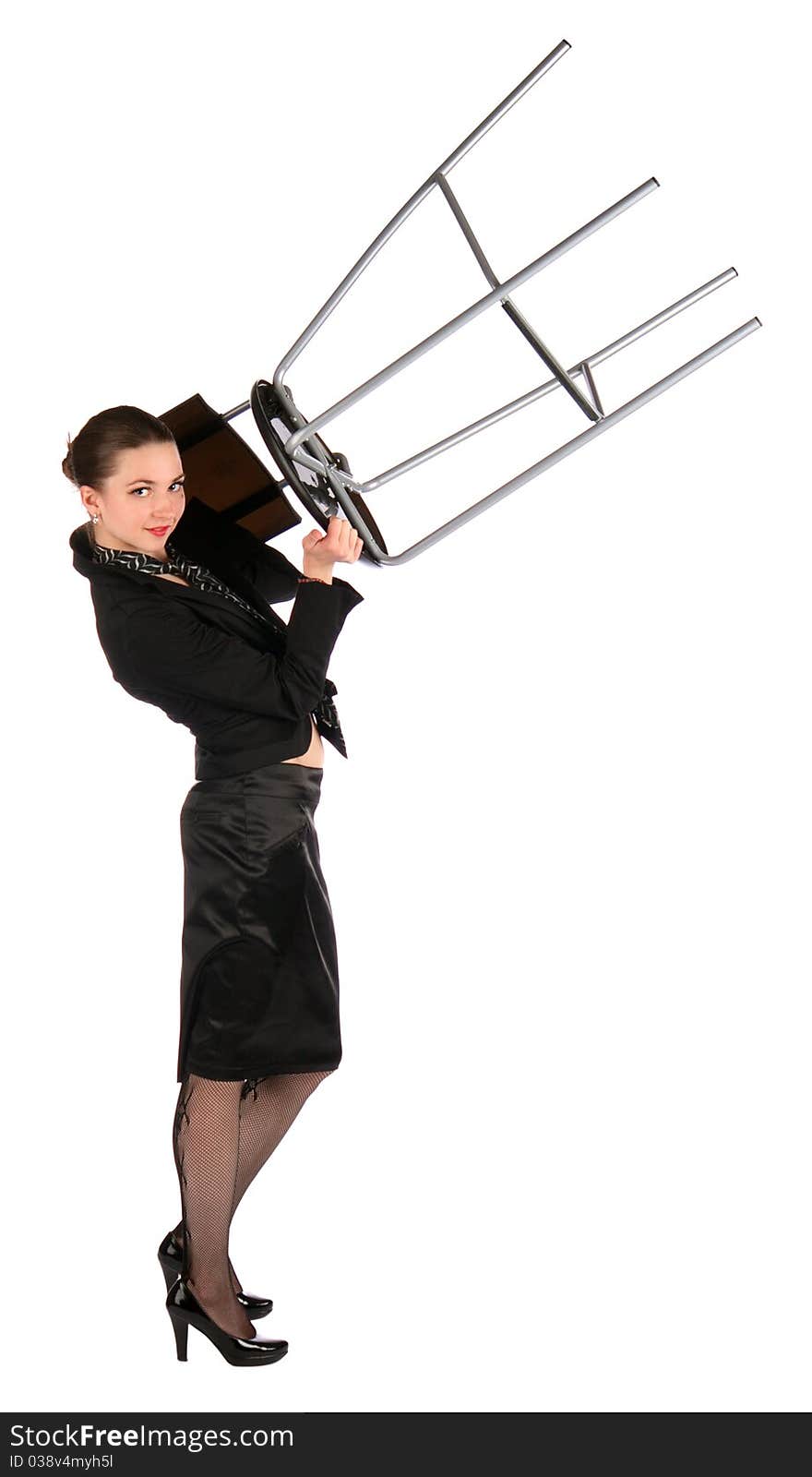 Girl in black suit holds stool up.