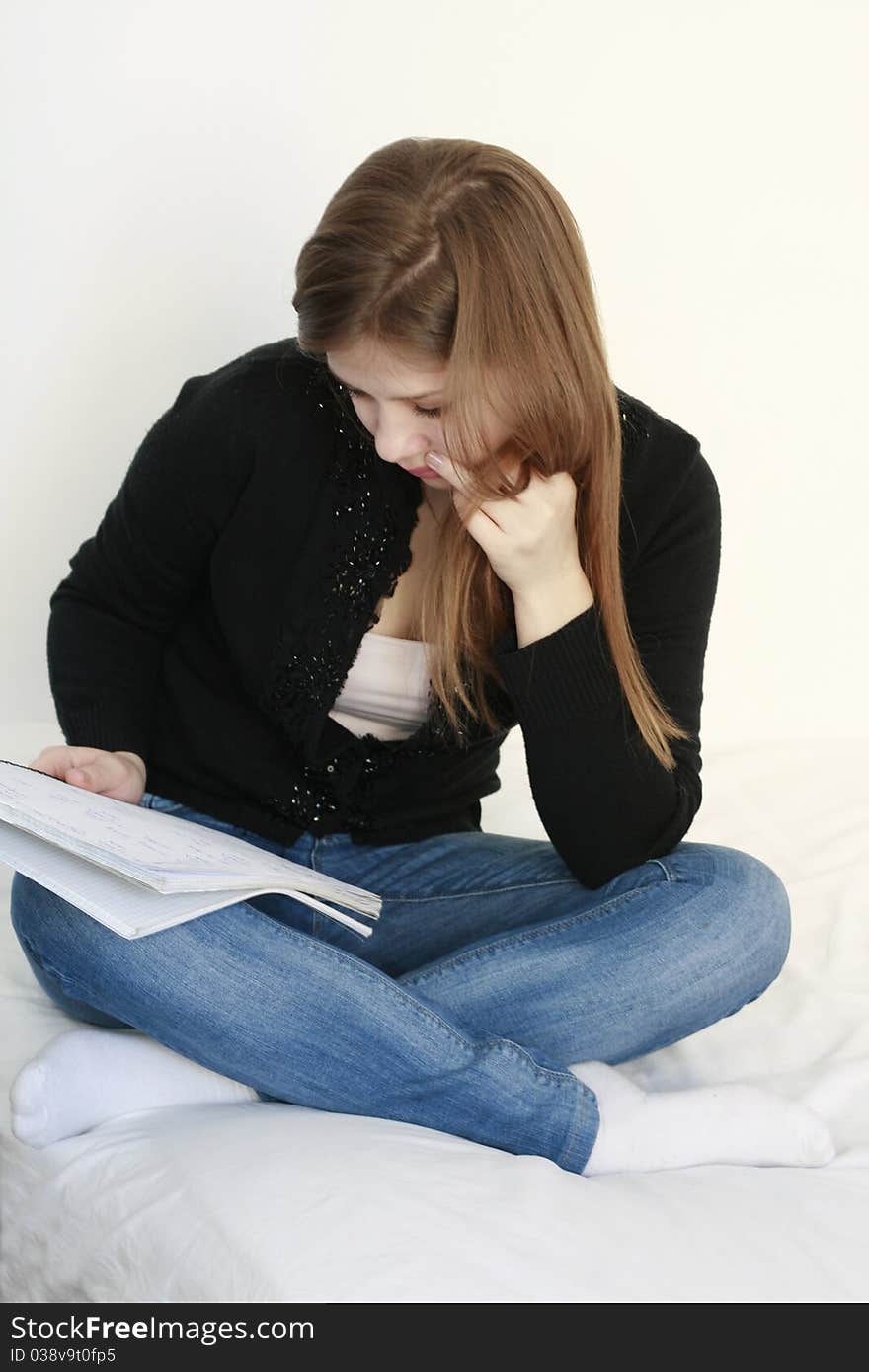 Teenage girl reading and learning in her bed isolated on white background. Teenage girl reading and learning in her bed isolated on white background