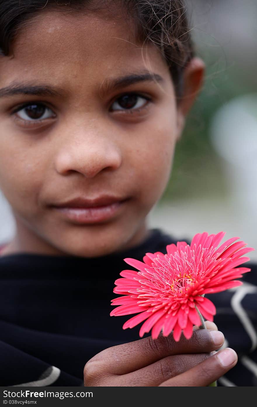 Little young village girl with pink flower in her hand. Little young village girl with pink flower in her hand.