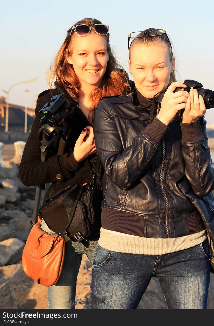 Portrait of two girls with a camera and tripod. Portrait of two girls with a camera and tripod.