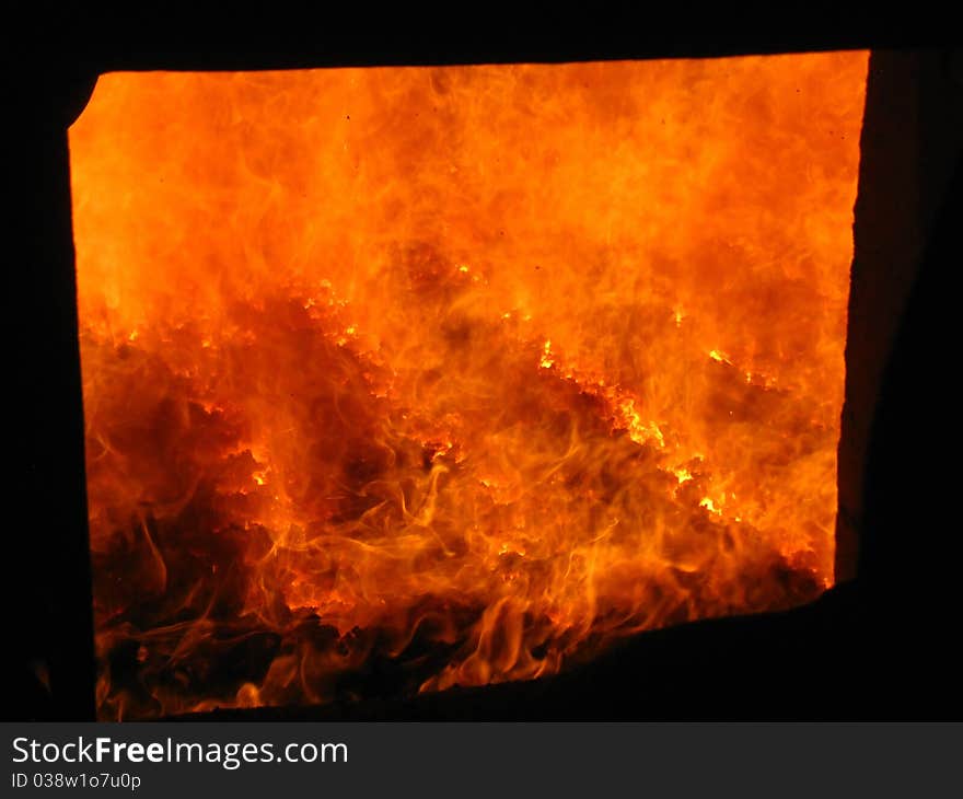 Fire in the coal boiler grate visible through an open manhole. Fire in the coal boiler grate visible through an open manhole