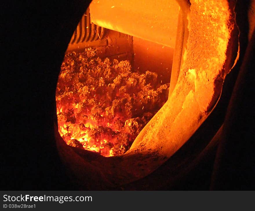 Fire in the coal boiler grate visible through an open manhole. Fire in the coal boiler grate visible through an open manhole