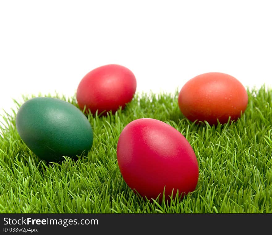 Colorful Easter eggs on green grass, with copy space