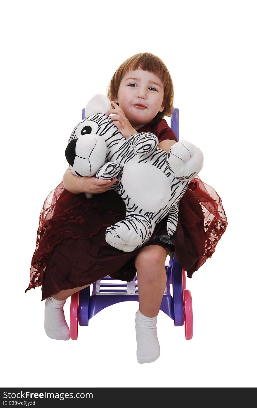 A sweet little girl, three years old, in a nice burgundy dress having fun with her stuffed animal, for white background. A sweet little girl, three years old, in a nice burgundy dress having fun with her stuffed animal, for white background.