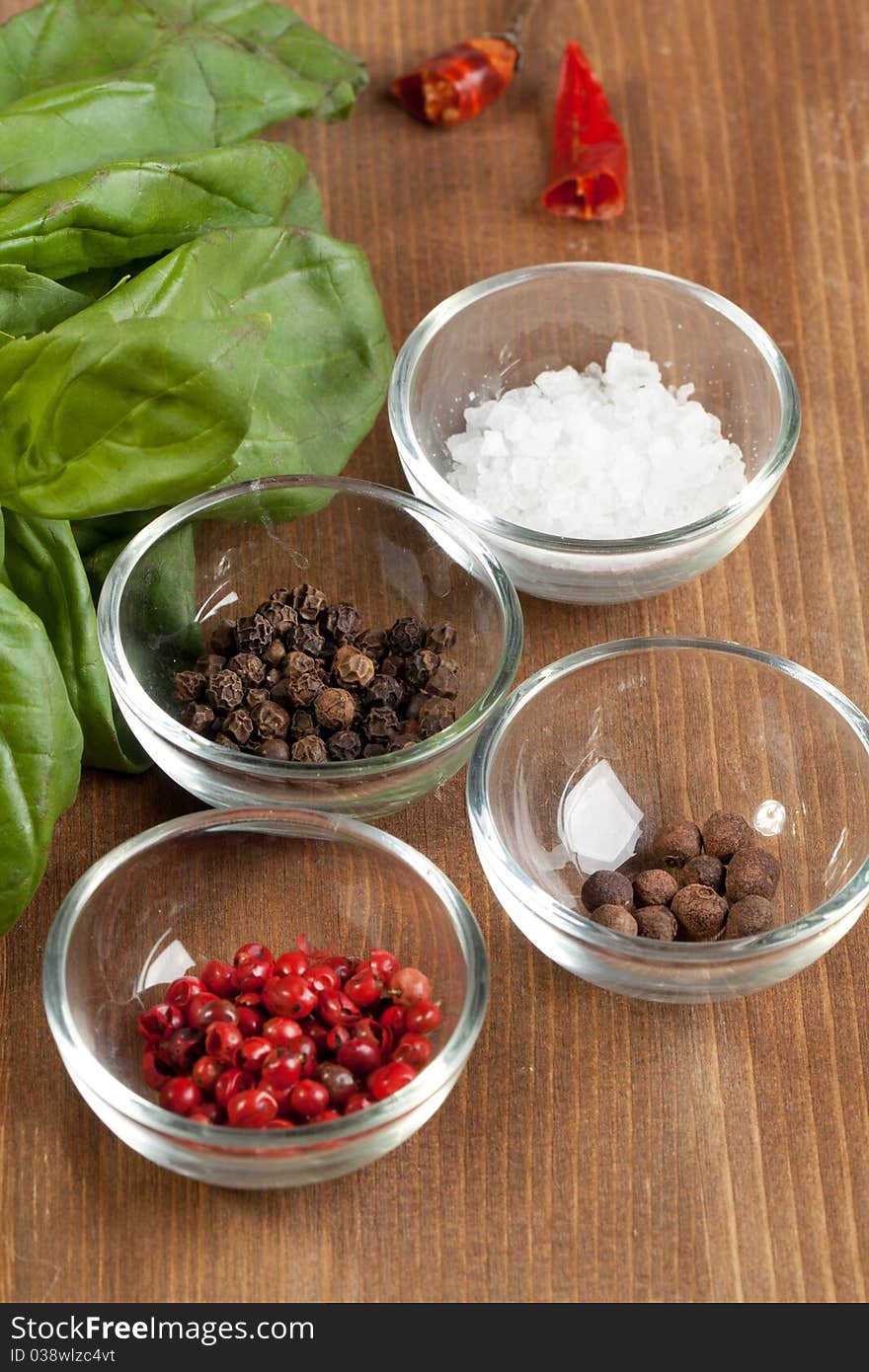 Salt and pepper's mix with fresh herb on the wooden desk