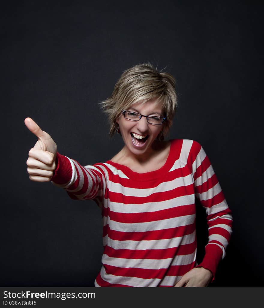 Portrait of attractive woman on black background showing thumb up. Portrait of attractive woman on black background showing thumb up