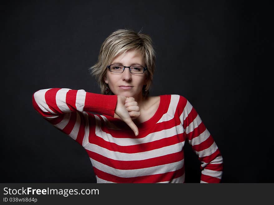 Portrait of attractive woman on black background showing thumb down. Portrait of attractive woman on black background showing thumb down