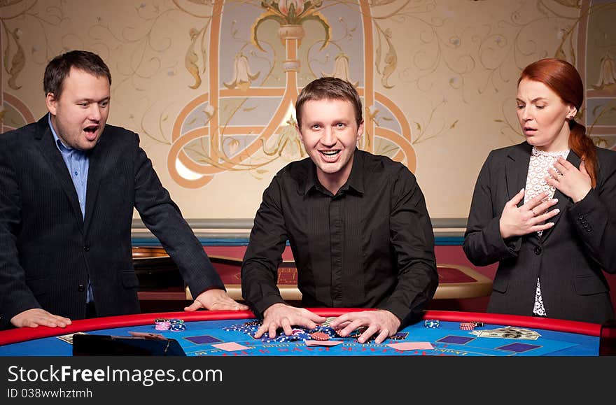 Group of people play poker on blue table