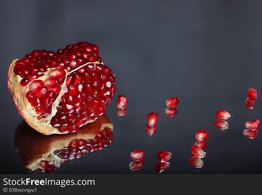 The portion of pomegranate with seeds on the mirror. The portion of pomegranate with seeds on the mirror