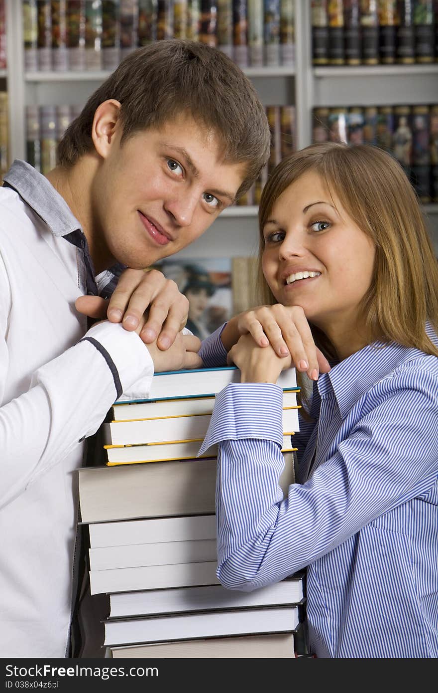 Young couple with stack of books in the booksop. Young couple with stack of books in the booksop