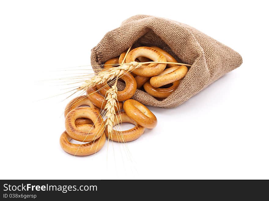 Burlap sack with bagels and ears on white