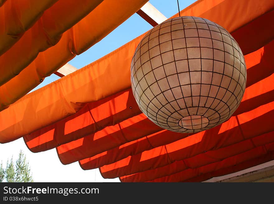 White paper lantern with orange patio cover. White paper lantern with orange patio cover.