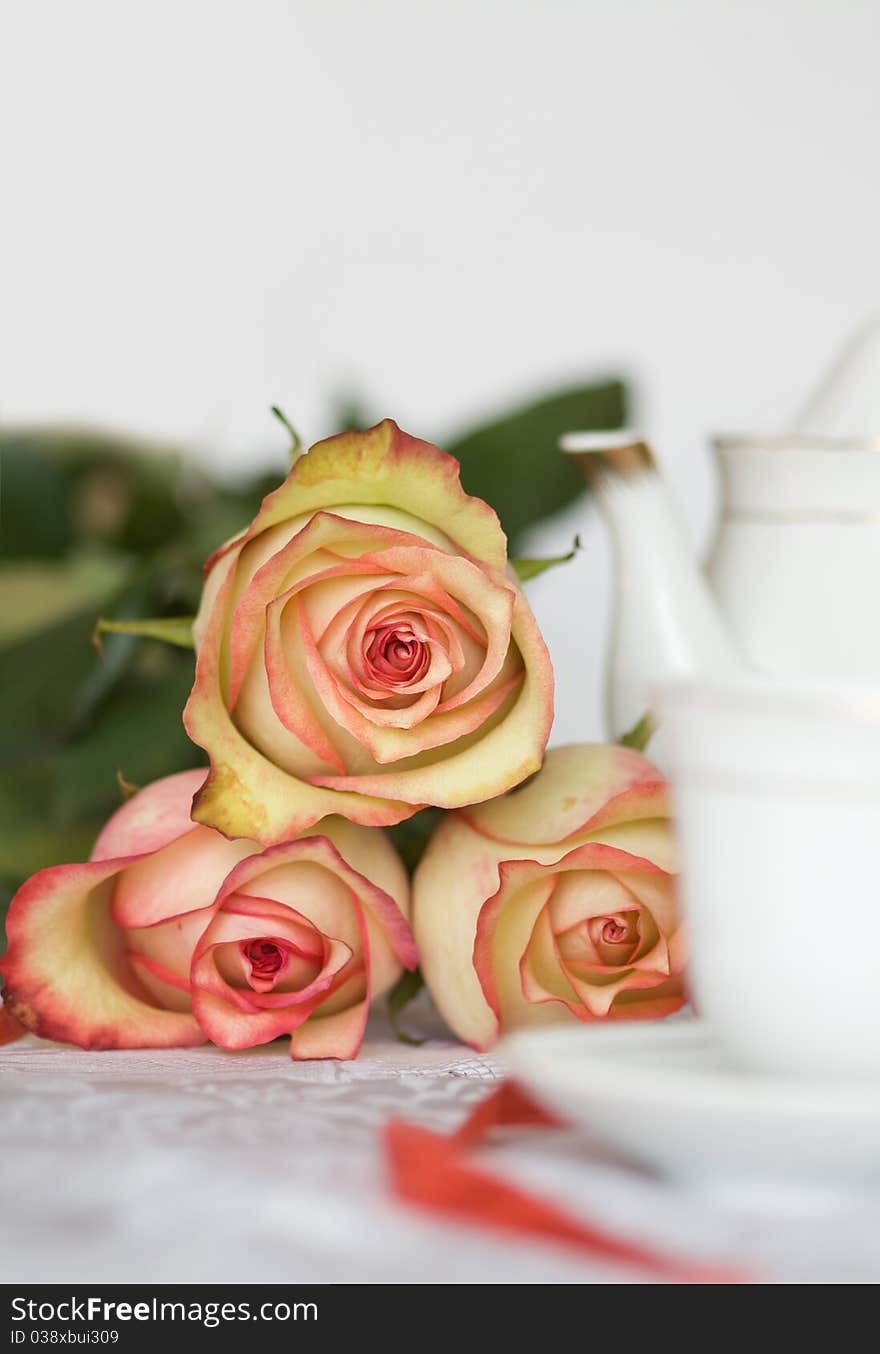 Beautiful roses and tea set on foreground. Beautiful roses and tea set on foreground