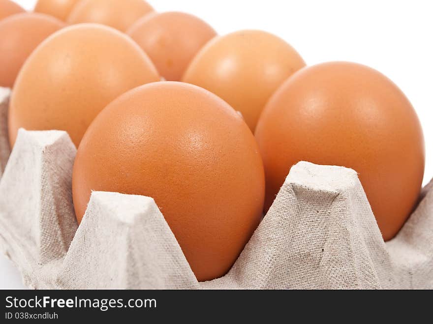 Brown eggs in box on white