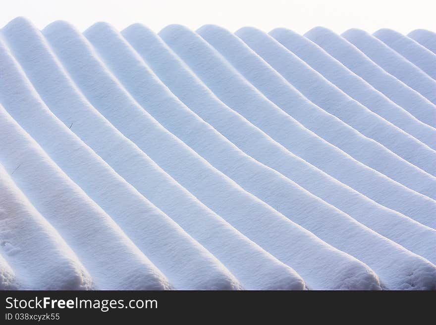 Lines in the snow made by a snowmobile,that was on the roof of buildings. Lines in the snow made by a snowmobile,that was on the roof of buildings.