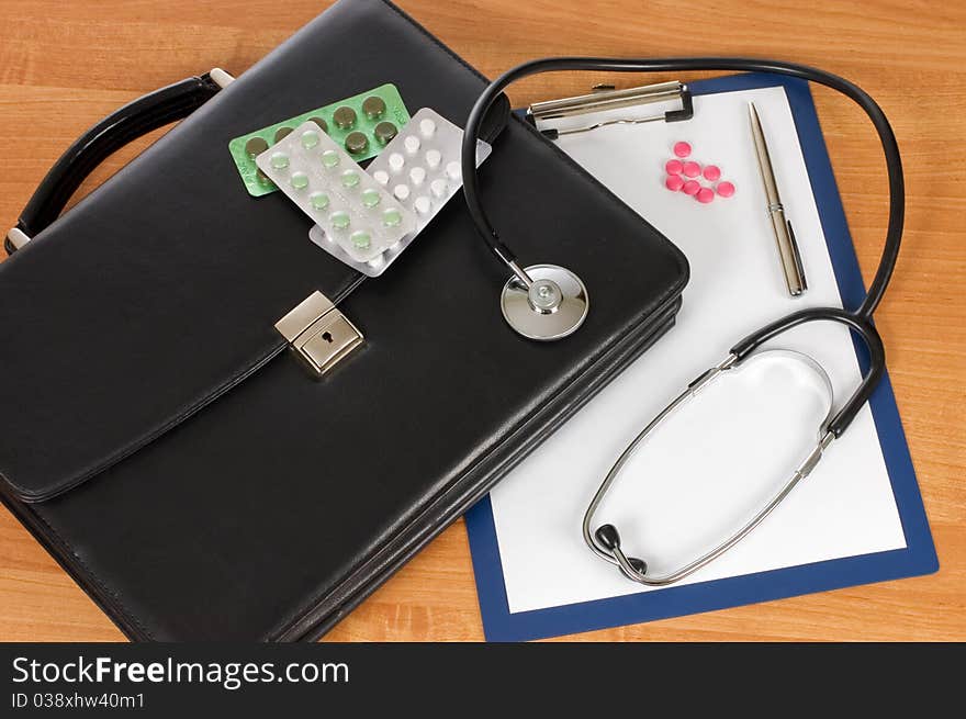 Black portfolio and phonendoscope on a table still life