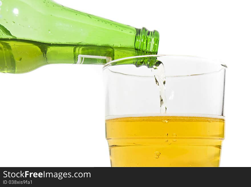 Pouring beer from a green beer bottle into a glass. Pouring beer from a green beer bottle into a glass