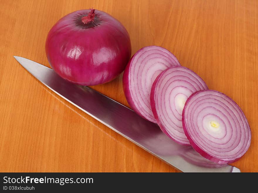 Red onion, slices and knife on the kitchen board. Red onion, slices and knife on the kitchen board