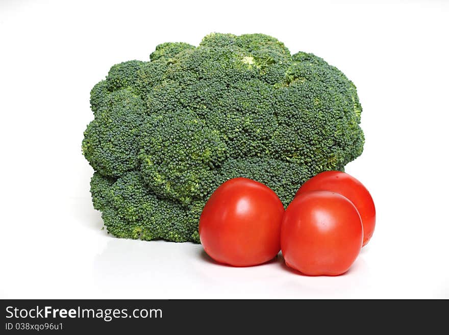 Fresh broccoli and tomato on a white background. Fresh broccoli and tomato on a white background