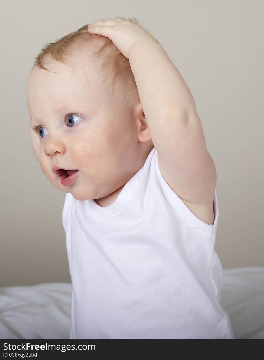 Cute baby boy with hands on head