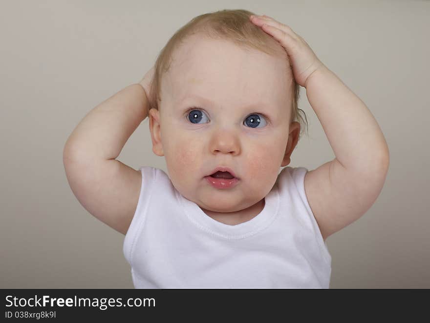 Cute baby boy with hands on head