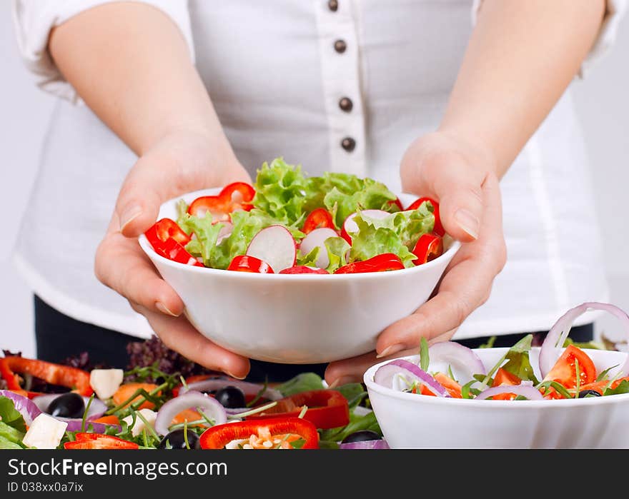 Woman hands showing fresh salad.