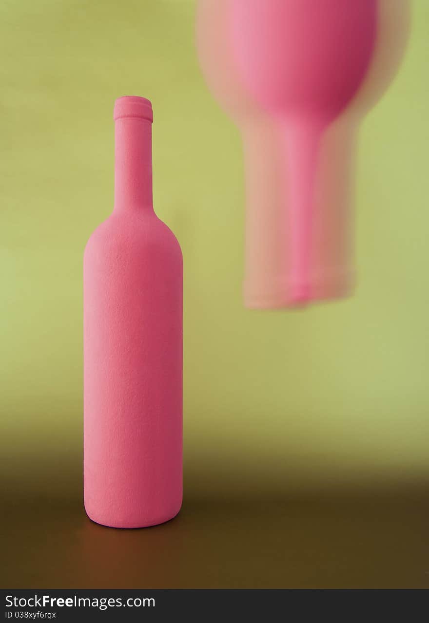 Two inverted red-pink bottle on golden background. Two inverted red-pink bottle on golden background