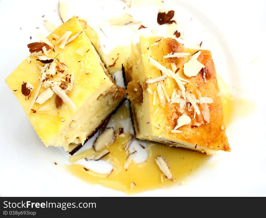 Top view of portion of curd pie with raisin, honey and almond on white plate. Top view of portion of curd pie with raisin, honey and almond on white plate