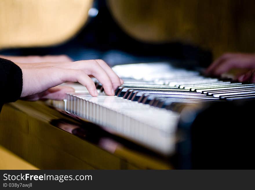 The fingers are playing the piano keyboard. The fingers are playing the piano keyboard