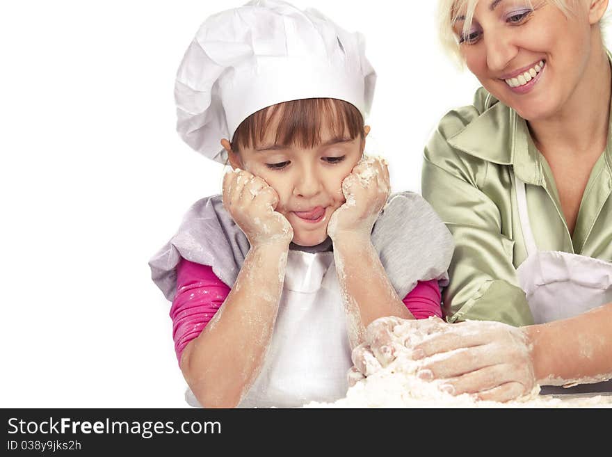 Happy, blond caucasian mother and daughter preparing dough and having fun