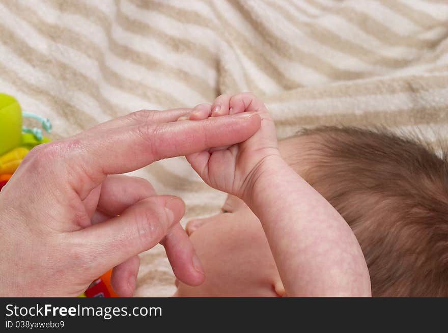 Little baby holding her mother's finger macro shot. Little baby holding her mother's finger macro shot