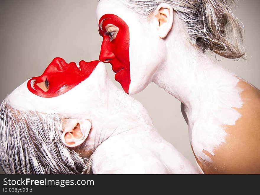 Two girls with painted faces delivering red heart pattern. Two girls with painted faces delivering red heart pattern