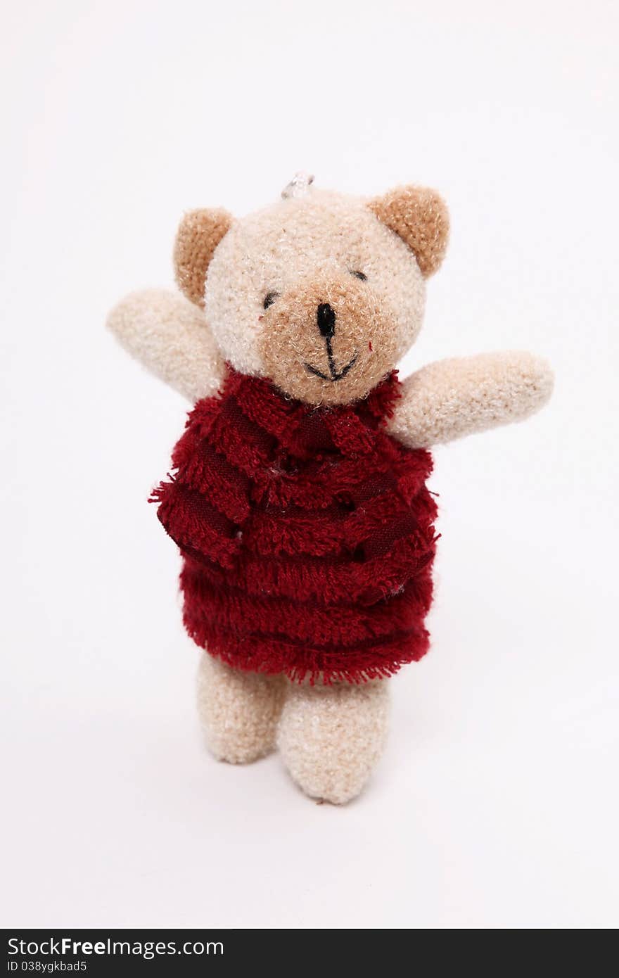 Teddy bear with red dress over white background