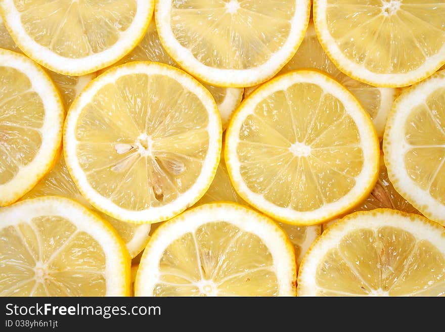 Some slices of ripe yellow lemons background. Some slices of ripe yellow lemons background