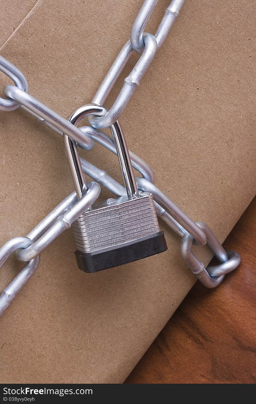 Metal lock and chain on a brown background.