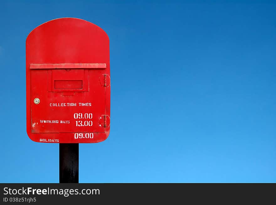 Red postbox and blue sky