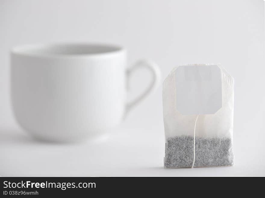 Tea bag and white cup. Tea bag and white cup