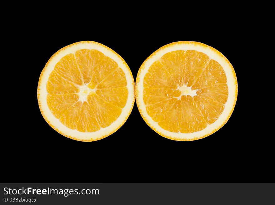 Two pieces of orange, showing texture on black background. Two pieces of orange, showing texture on black background.