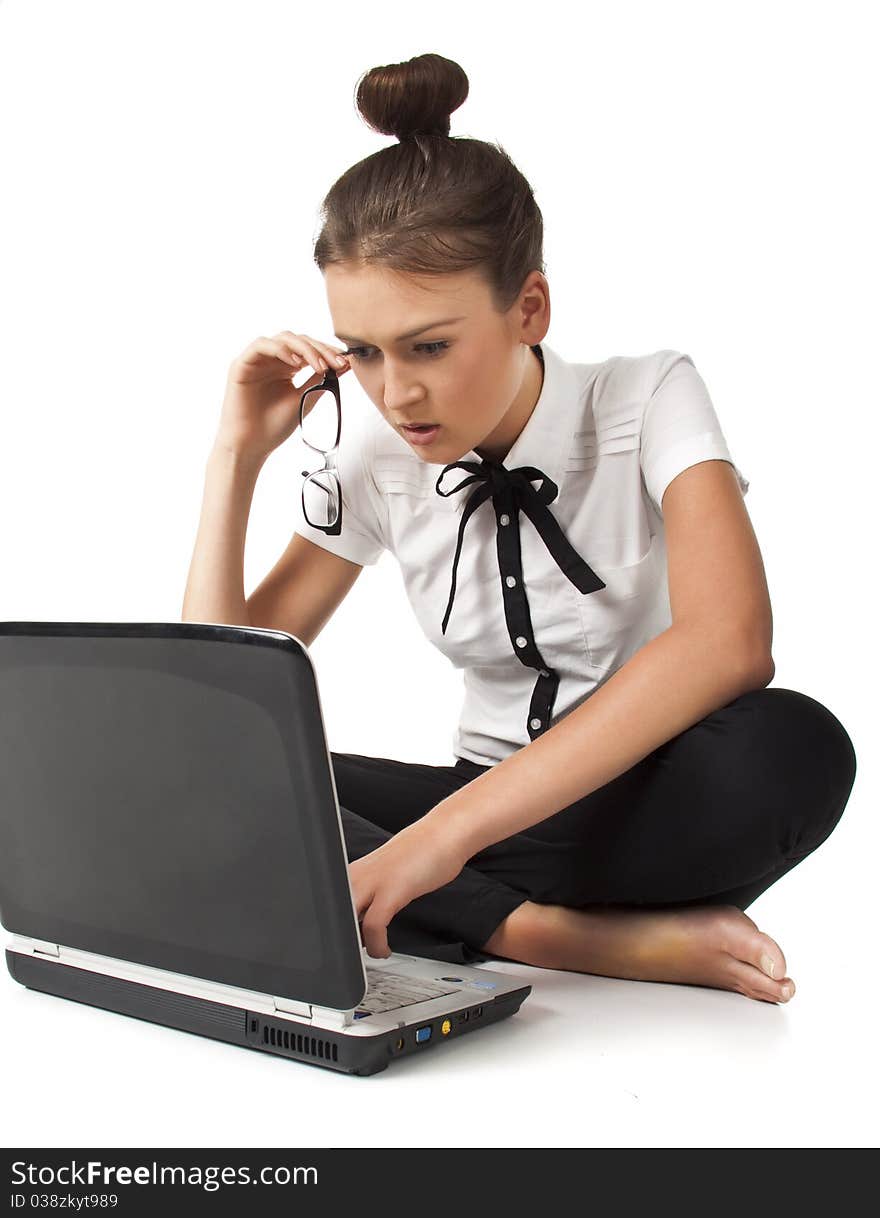 Beautiful girl sitting on the floor and works on a laptop keep the glasses in her hand isolated on white background Student Series